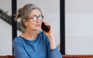 Seniorin mit schnurlosem Telefon